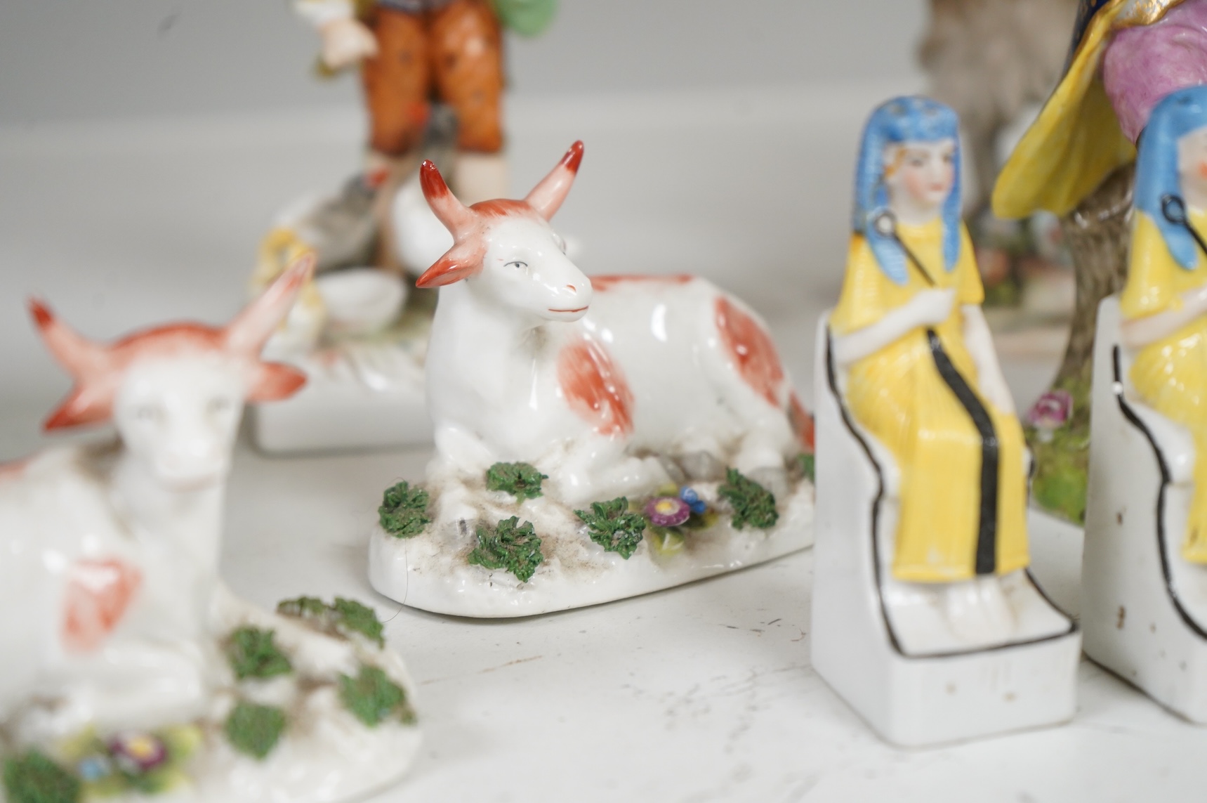 Two Derby porcelain seated figures emblematic of summer and autumn and a collection of Continental porcelain figures to include a pair of recumbent cows, largest 18cm high
